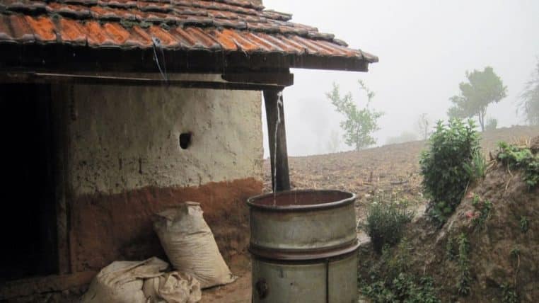 Bidons alignés recueillant l’eau de pluie pour un usage domestique.