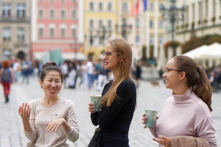Deux amies en pleine conversation, tasses de café à la main.