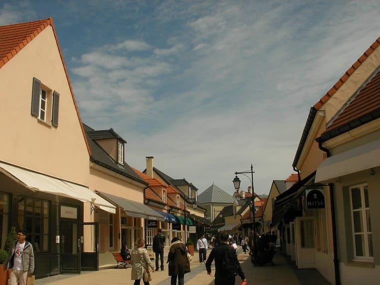 Rue pavée de La Vallée Village, éclairée naturellement.