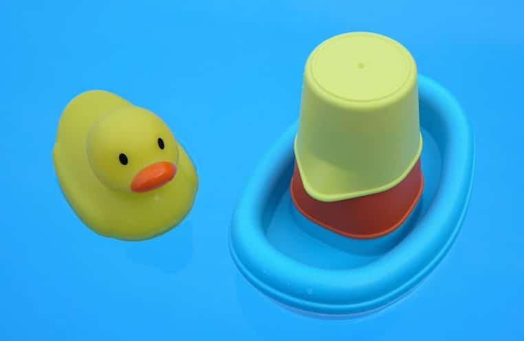 Canard de bain jaune flottant sur l’eau d’une baignoire.