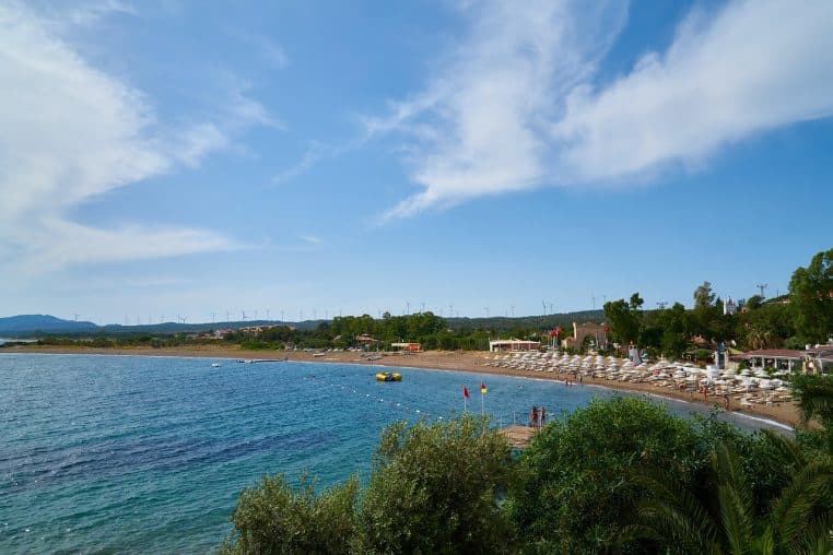 Façade d’hôtel avec transats face à la mer.