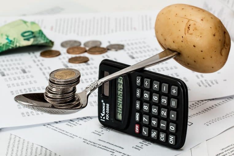Calculatrice sur laquelle sont posées des pièces de monnaie.