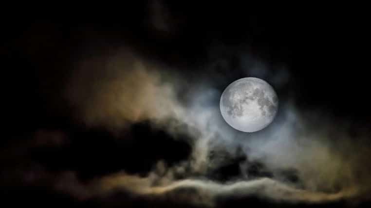 Pleine lune brillante dans un ciel nocturne nuageux.
