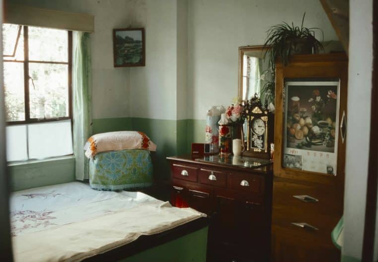 A bedroom with a bed, dresser, and window