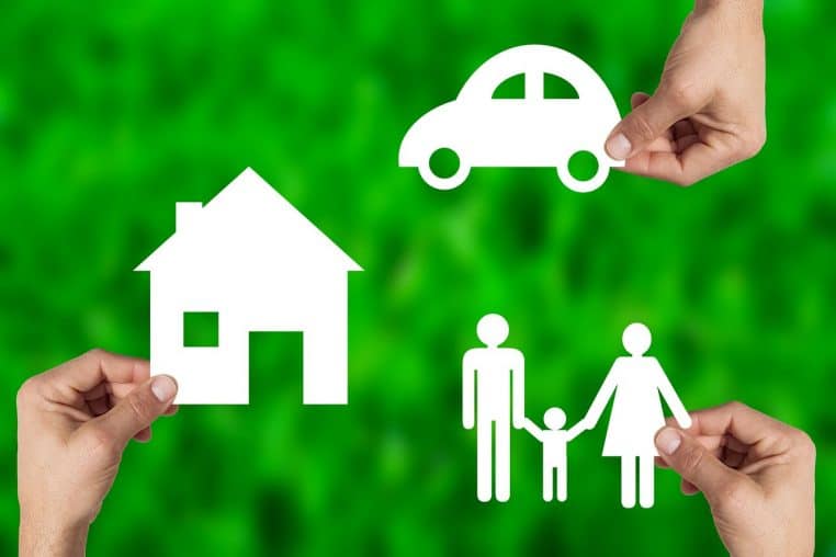 Figurines de maison, voiture et silhouettes de personnes.