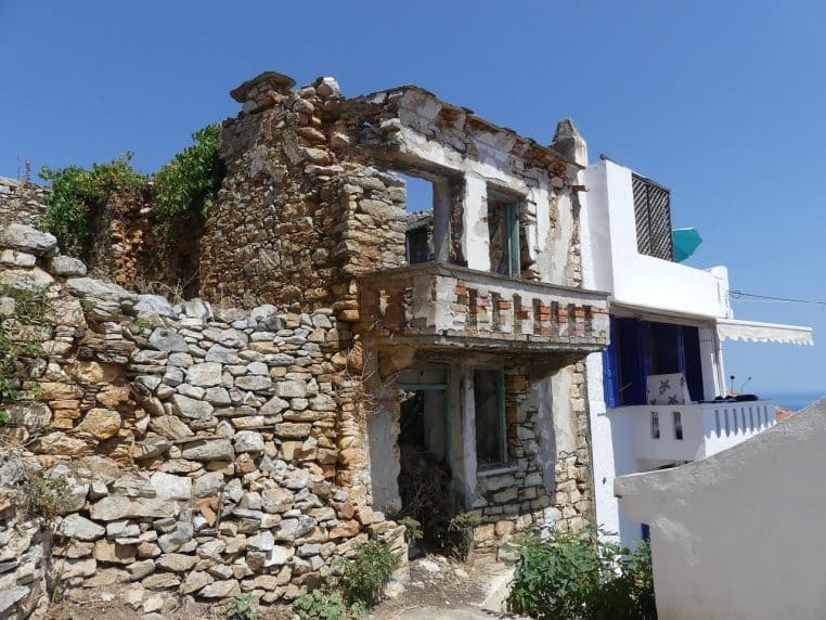 Murs en pierre délabrés sous un ciel bleu, symboles d’une histoire ancienne.