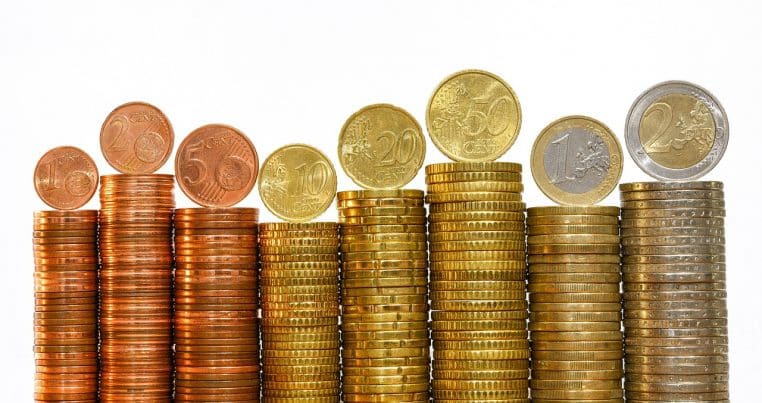 Gros plan de plusieurs pièces de 1 € empilées et dispersées.