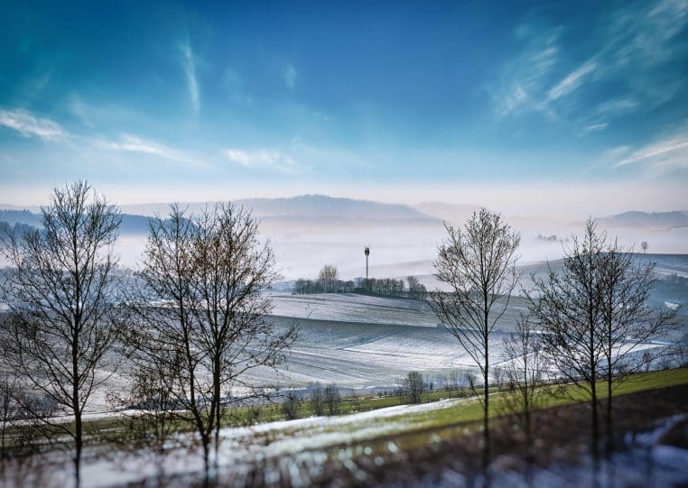 Pylône cellulaire s’intègrent à un paysage champêtre emplis de neige, illustration de l’omniprésence des réseaux mobiles.