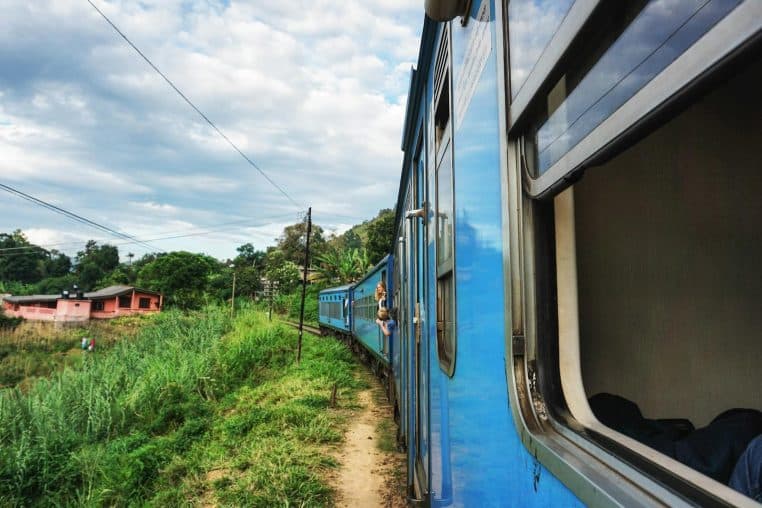 A train travels through vibrant countryside, offering stunning views and a memorable journey.