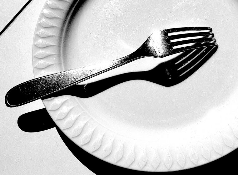 fourchette sur assiette en lumière rasante.