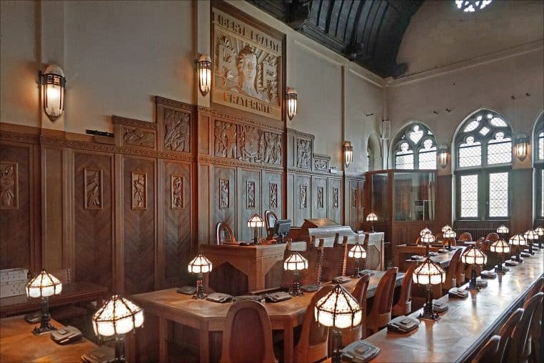 Salle du conseil municipal avec sièges rouges et boiseries.