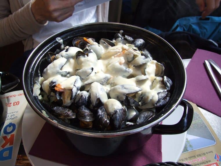 Casserole de moules-frites recouverte de fromage fondant.