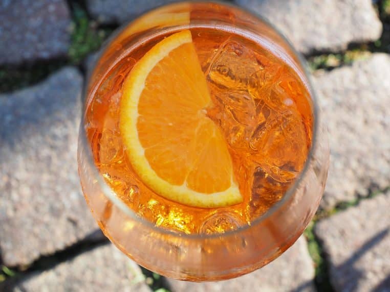Deux verres d’Aperol Spritz orange sur une table.