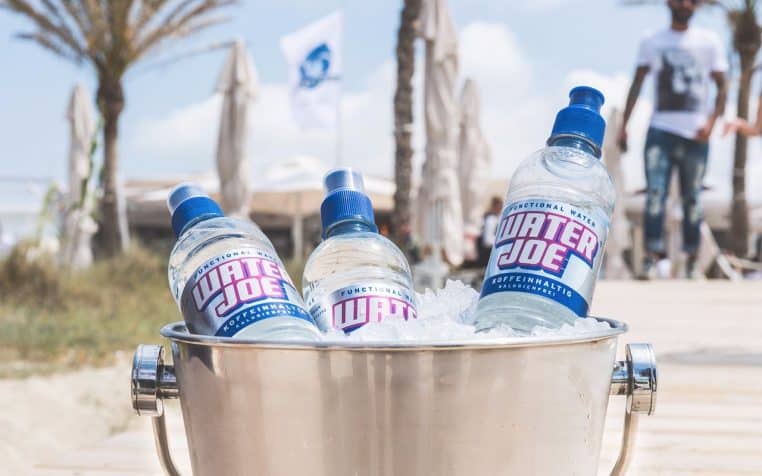 Seau à champagne planté dans le sable face à la mer.