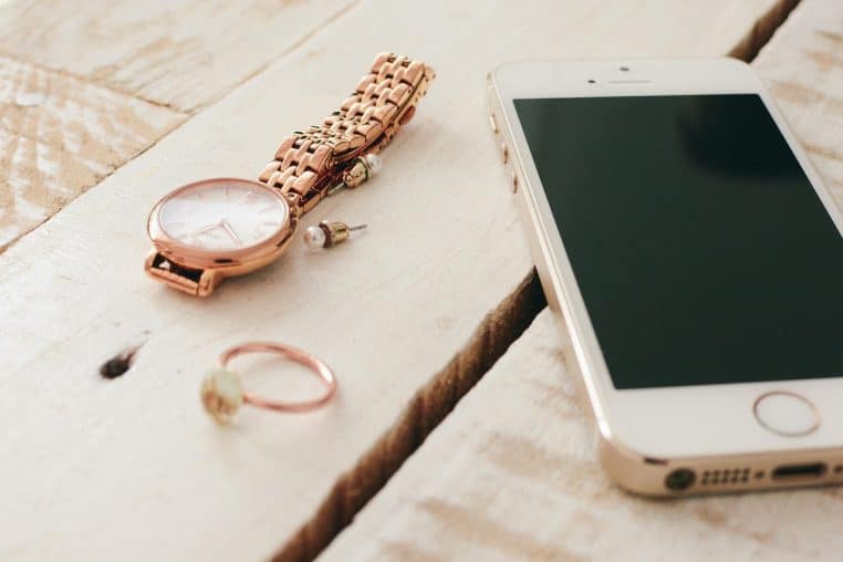 iPhone connecté au chargeur sur surface bois avec effets de lumière.