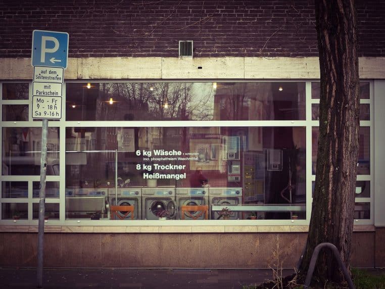 Vitrine d’un commerce avec machines à laver derrière la baie.