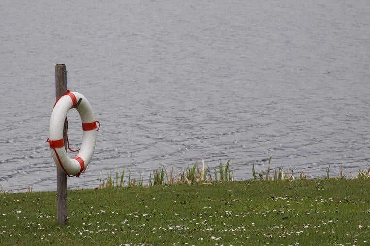 Bouée de sauvetage posée sur un ponton au bord d’un lac.