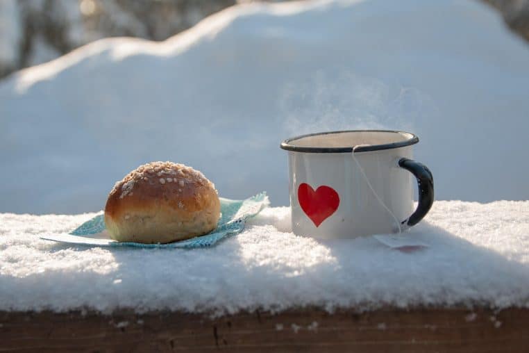 Repas de pique-nique posé sur une table en bois, sandwichs et thermos.