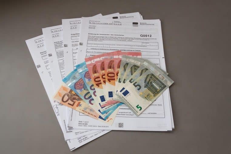 Formulaire de pension posé sur une table avec billets en euros.