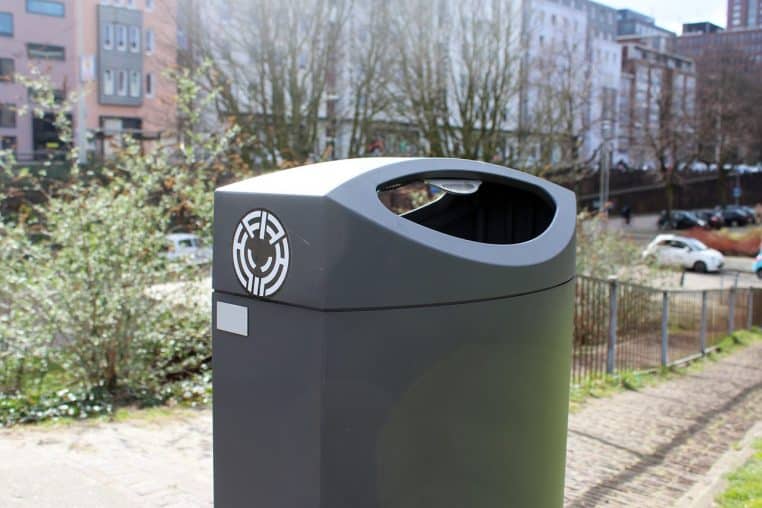 Poubelles sur un trottoir urbain.