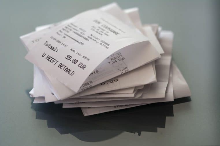 Tickets de caisse en euros étalés sur une table.