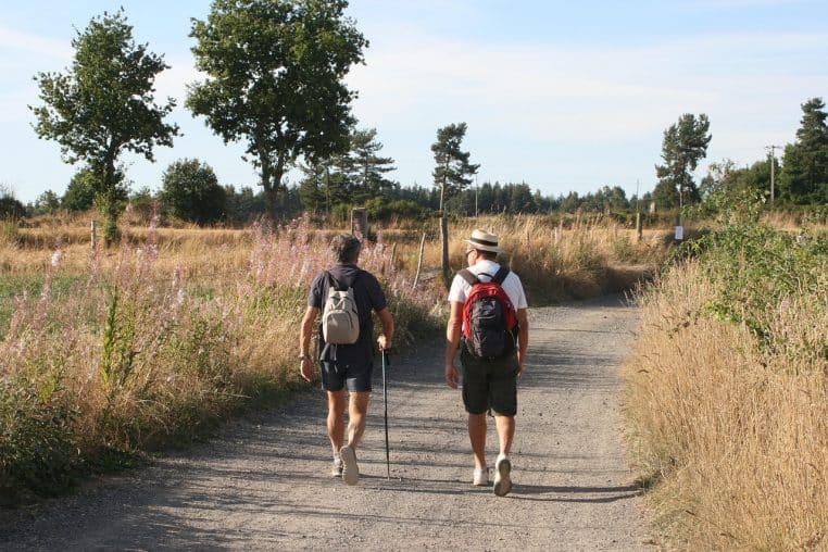 Deux personnes marchant sur un chemin de campagne .