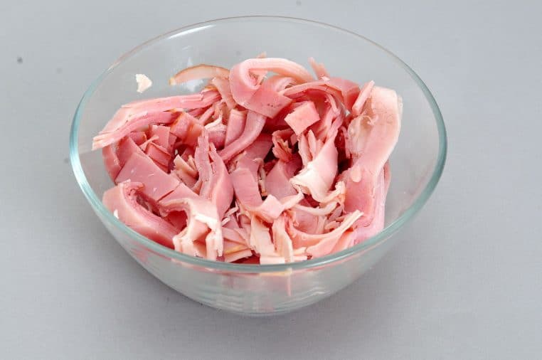 Assiette avec tranches de jambon cuit en gros plan.