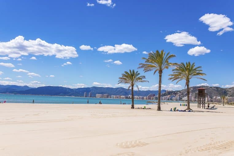 Large plage de Cullera avec front de mer et parasols.