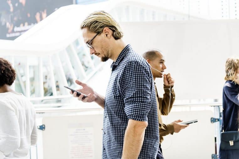 Plusieurs personnes concentrées sur leurs écrans en marchant