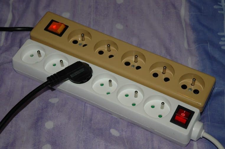 Deux multiprises françaises, l’une à cinq prises, l’autre à six, posées au sol