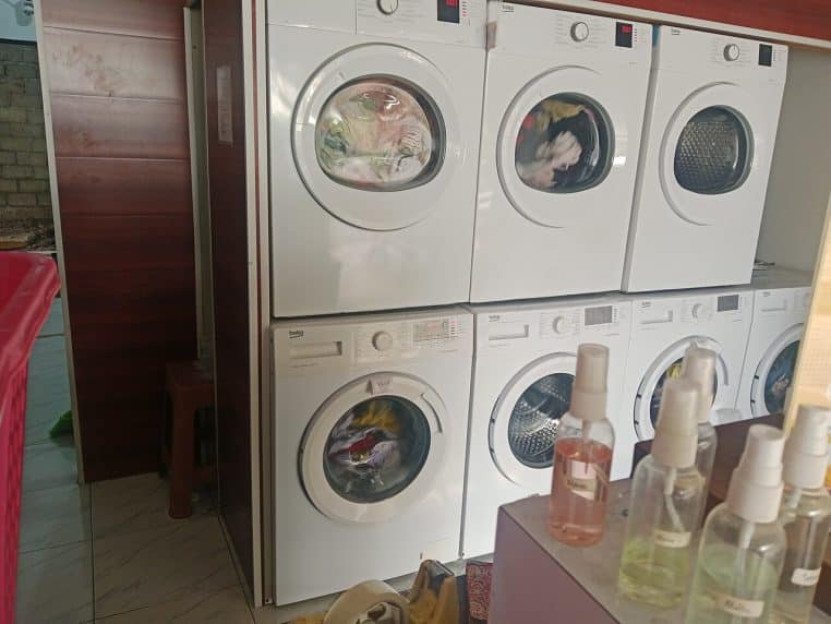 Rangée de machines à laver dans une laverie.