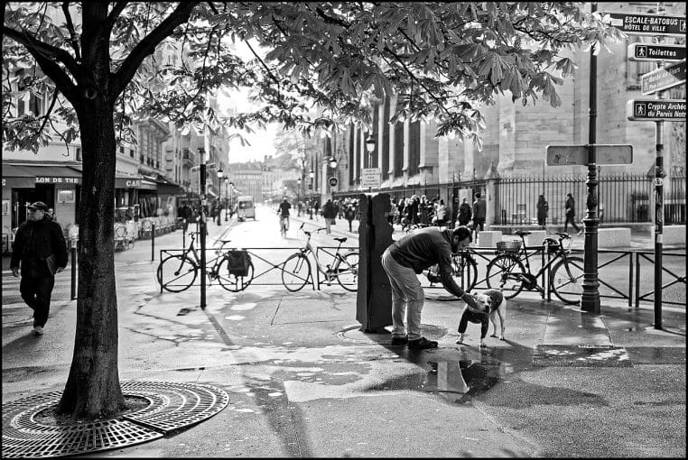 Rue parisienne un matin, ambiance douce et lumineuse, passants en mouvement