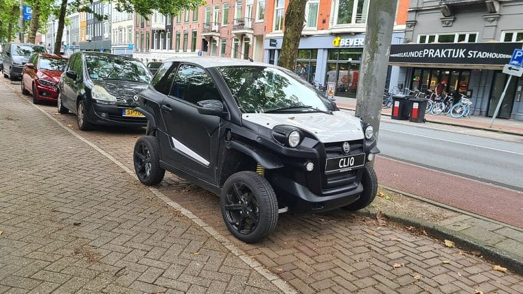 Microcar Aixam e-Scouty gris, vue de trois-quarts avant, stationnée en extérieur.