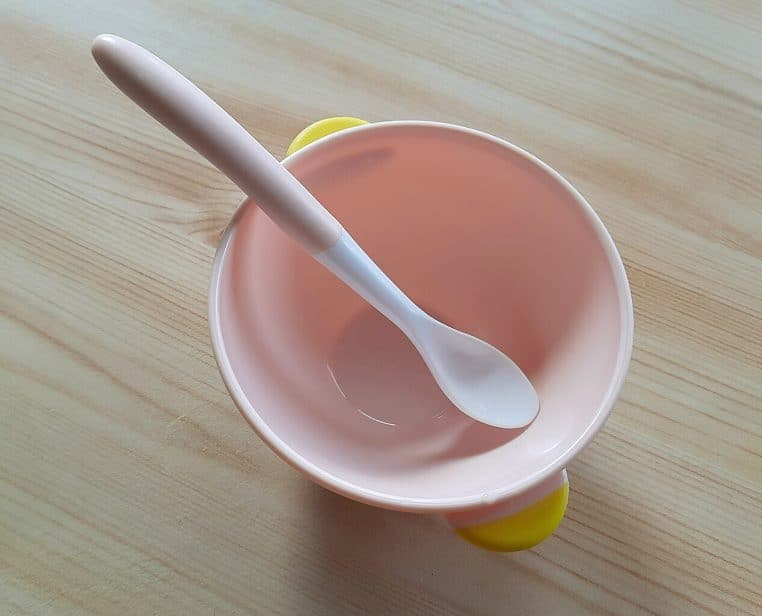 Bol et cuillère pour l’alimentation des nourrissons posé sur une table