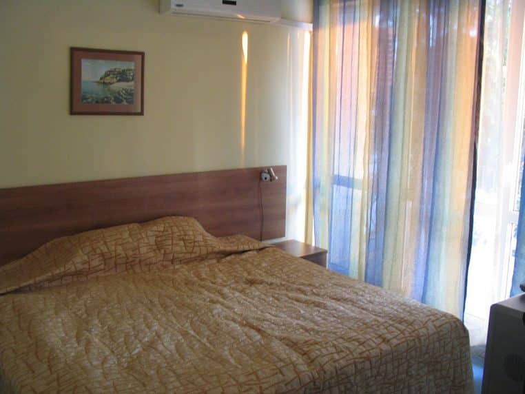 Chambre d’hôtel avec lit double et lumière douce.