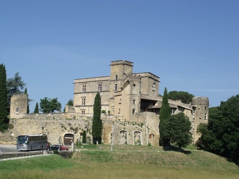 Château de Lourmarin entouré de végétation, ciel bleu, vue paysage