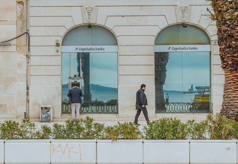 Homme de dos utilisant un distributeur automatique de billets