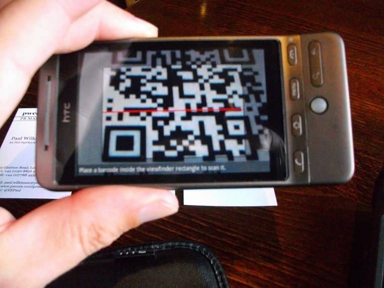 Smartphone scannant un QR code imprimé sur une carte