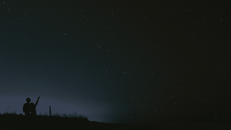 Silhouette d’un couple observant un ciel étoilé.