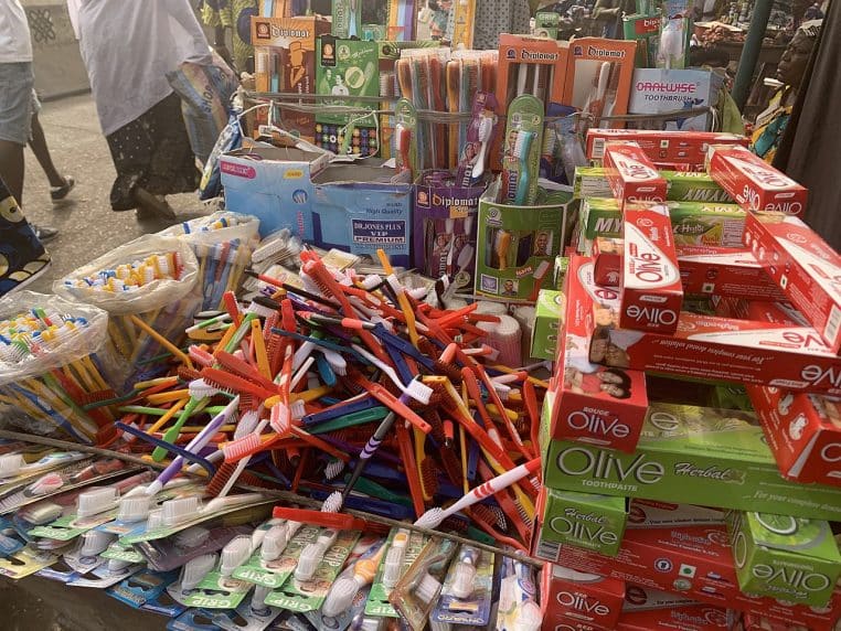 Gros plan d’une brosse à dents avec dentifrice en décor neutre.