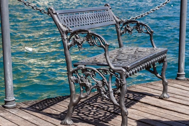 Banc public face à l’eau dans un parc, image paisible de retraite