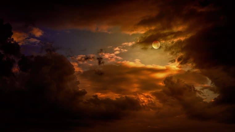 Lune entre des nuages nocturnes, ciel texturé et dramatique.
