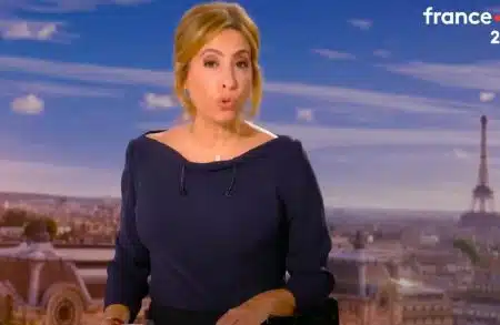Léa Salamé, présentatrice du JT de 20h sur France 2 en plateau, arrière-plan avec la tour Eiffel et le ciel bleu de Paris.