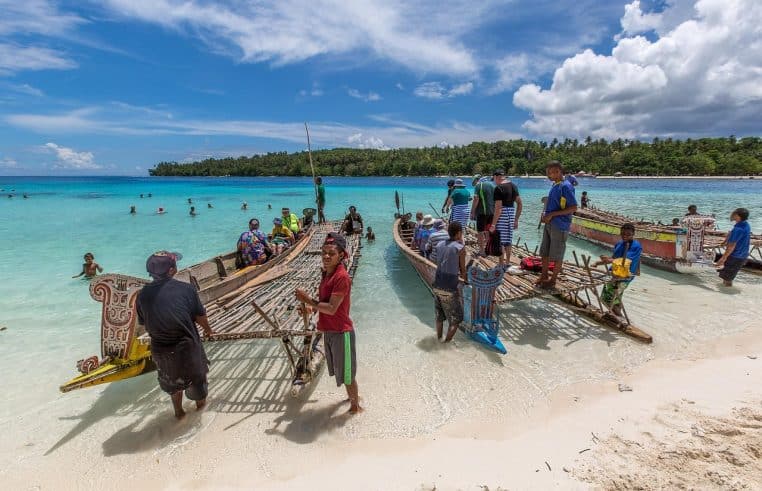 pirogue à balancier glissant sur une mer turquoise en Papouasie-Nouvelle-Guinée