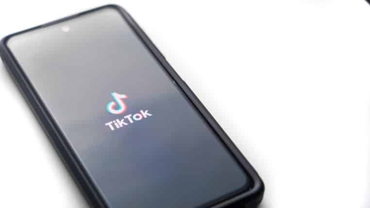 Écran de smartphone affichant l’app TikTok, gros plan, fond flou