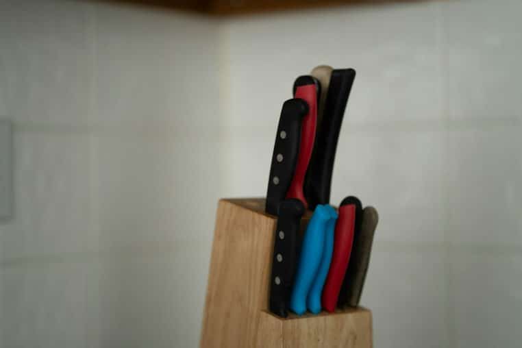 a set of knives sitting on top of a wooden block