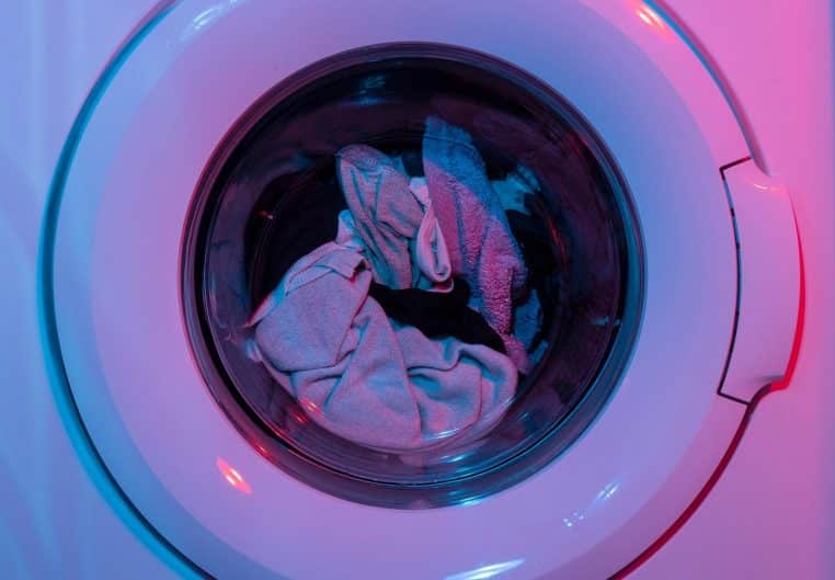 Gros plan sur tambour de lave-linge en inox, prêt pour un programme éco.