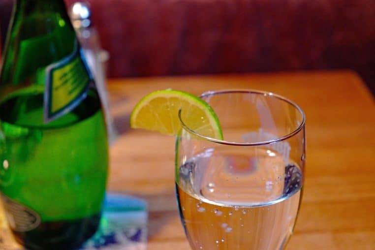 verre d’eau minérale avec quartier de citron et perles d’eau