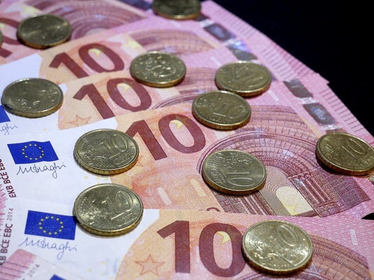 Billets de 10 € et pièces de 10 centimes posés sur une table