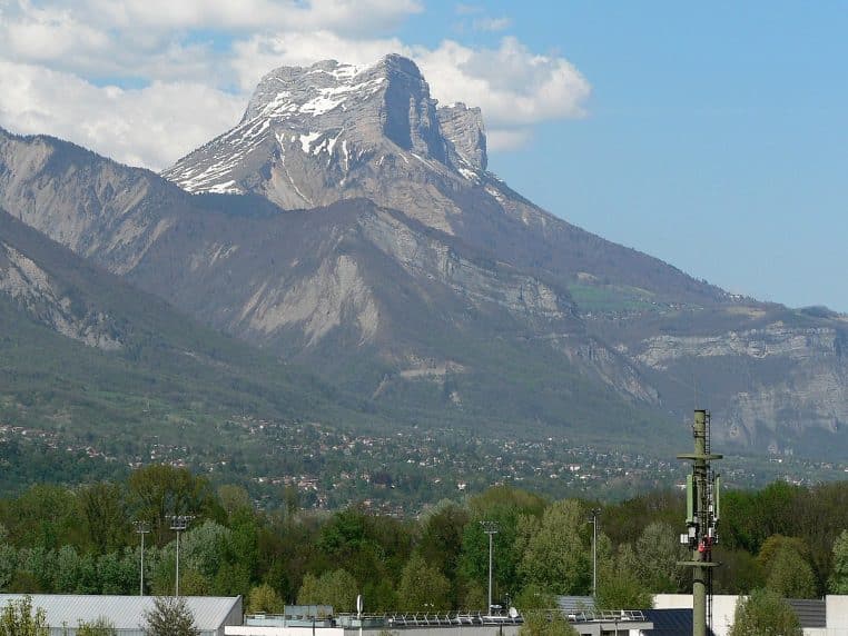 Technicien vérifiant une antenne mobile en montagne.